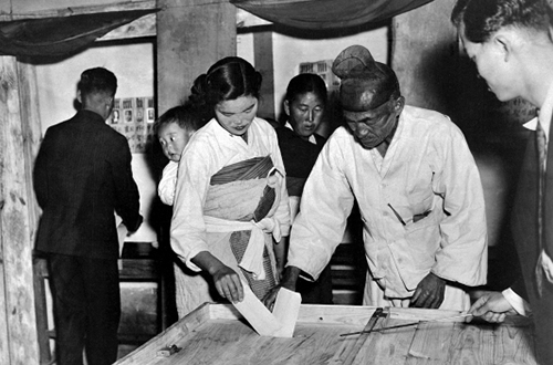 아이를 업고 투표하는 여인과 할아버지(1948)
