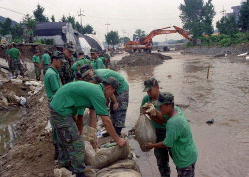 수해복구를 위해 강둑을 쌓고있는 군인들(1998)